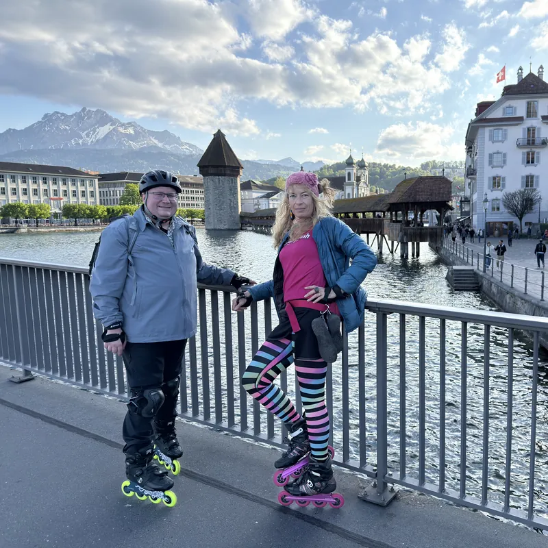 Skaters on a bridge in Lucerne with the Chapel Bridge behind